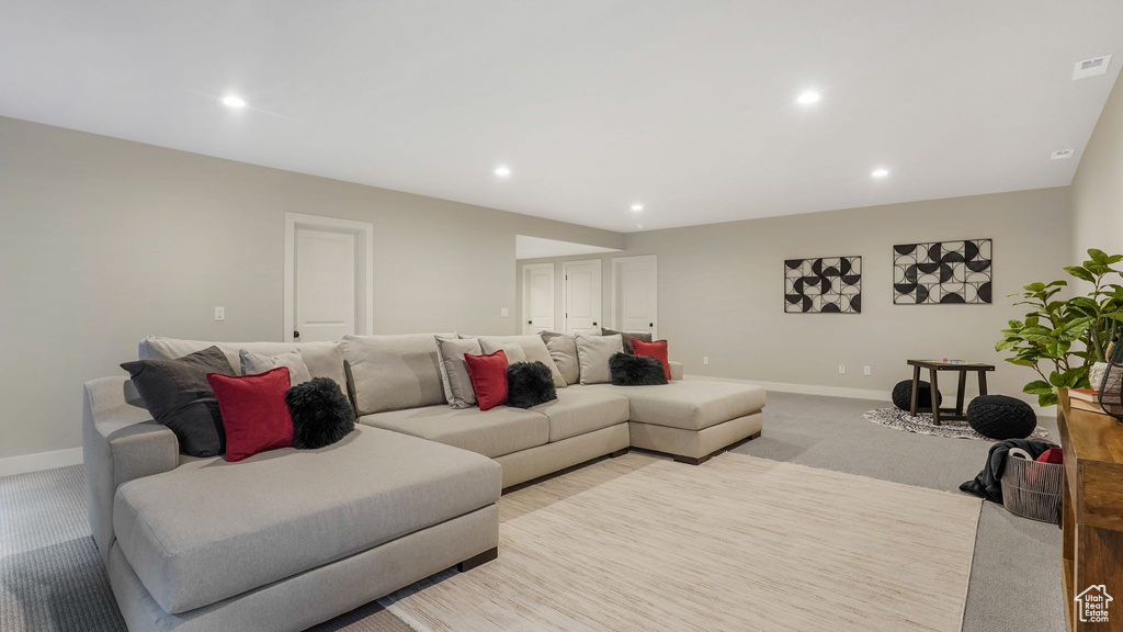 Living room featuring baseboards, recessed lighting, and light carpet