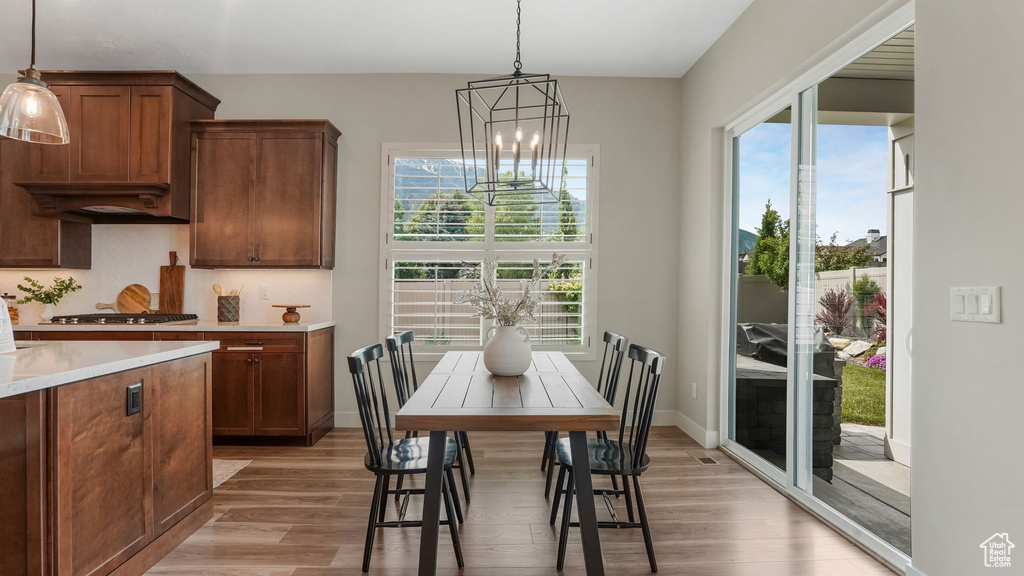 Dining room featuring a chandelier, light wood-style flooring, and baseboards