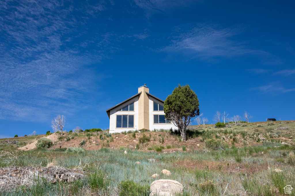 View of property exterior featuring stucco siding and a chimney
