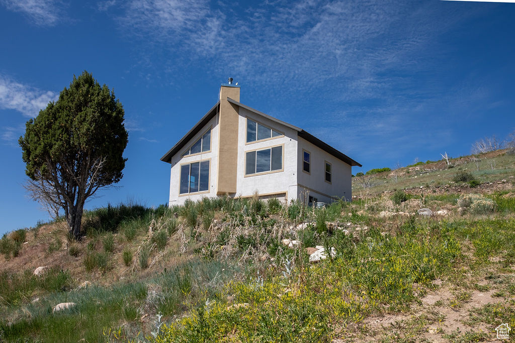 View of home's exterior with a chimney and stucco siding