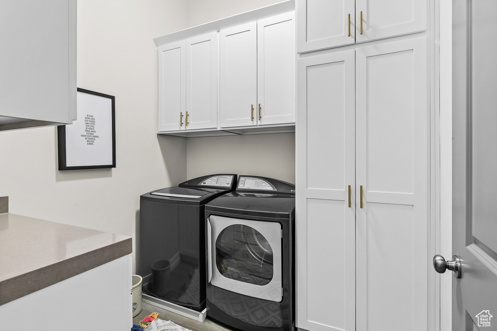 Washroom with cabinet space and washer and clothes dryer