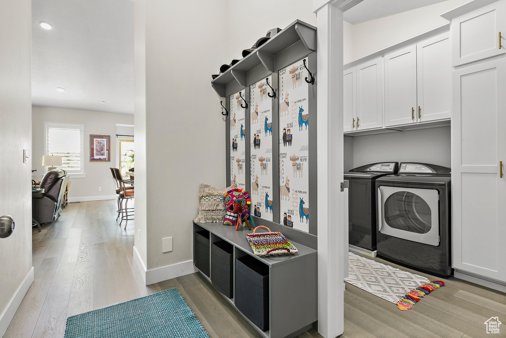 Mudroom featuring independent washer and dryer, light wood finished floors, baseboards, and recessed lighting