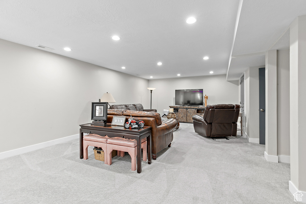 Living area with light carpet, recessed lighting, and baseboards