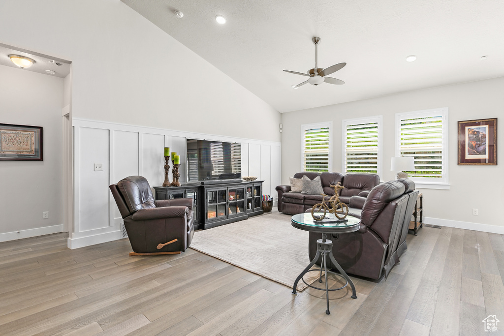 Living room with a ceiling fan, light wood finished floors, high vaulted ceiling, and recessed lighting