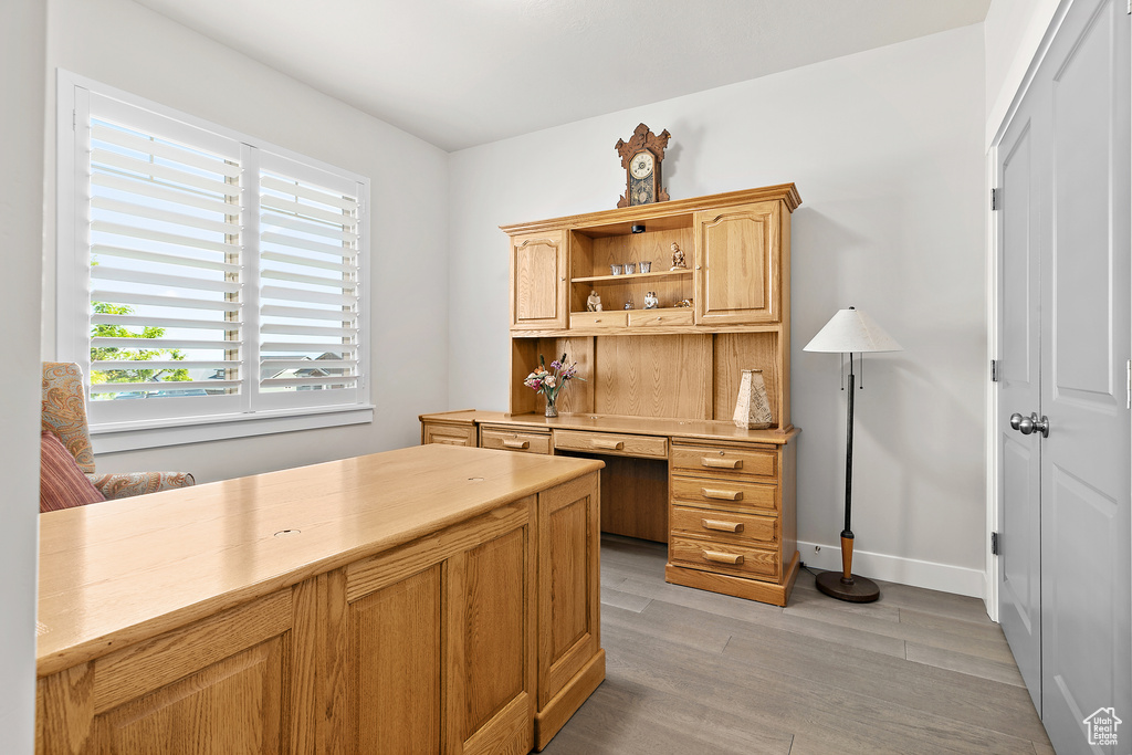 Office with light wood-style floors and baseboards