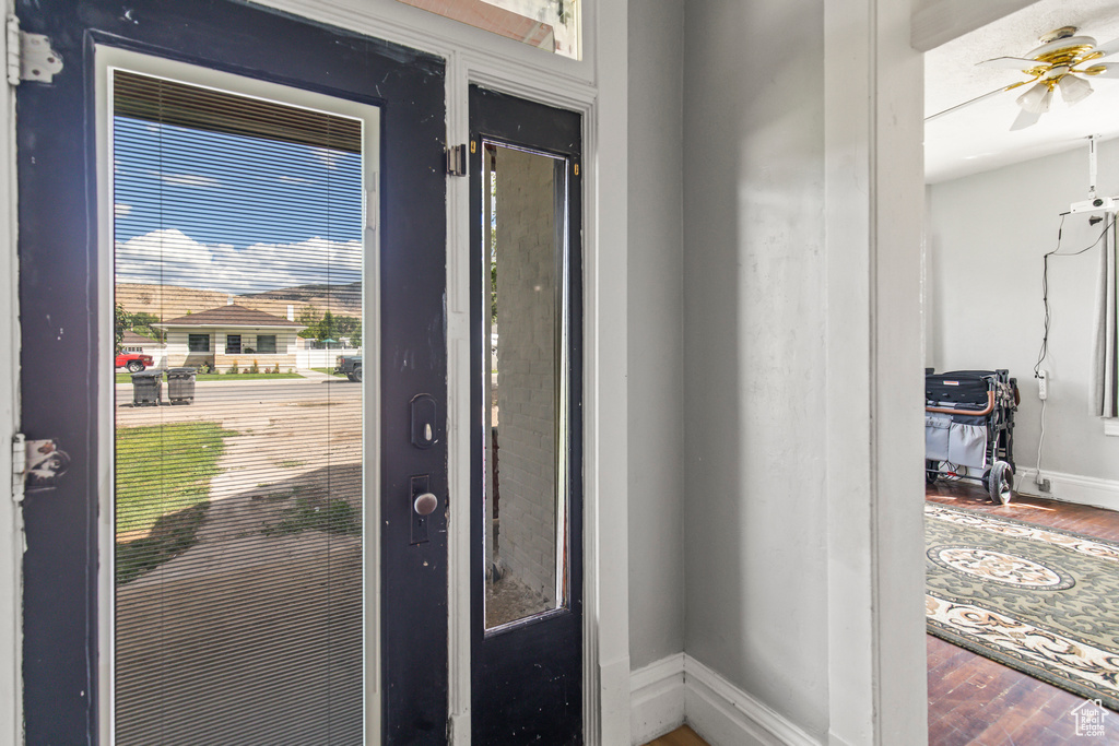 Entryway featuring baseboards, wood finished floors, and ceiling fan