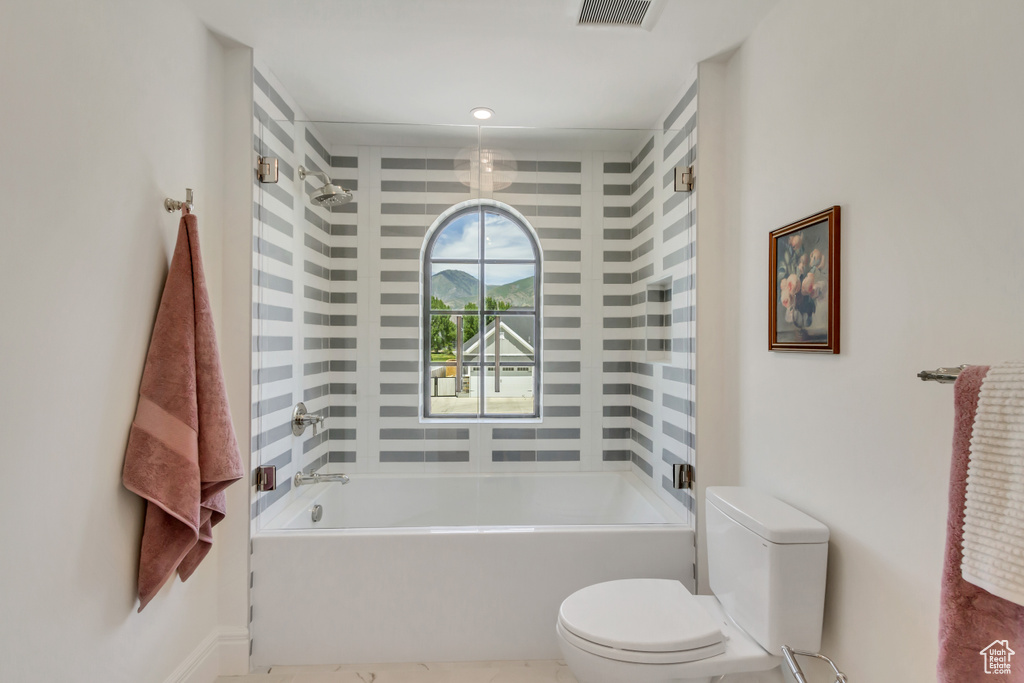 Bathroom featuring toilet and shower / washtub combination