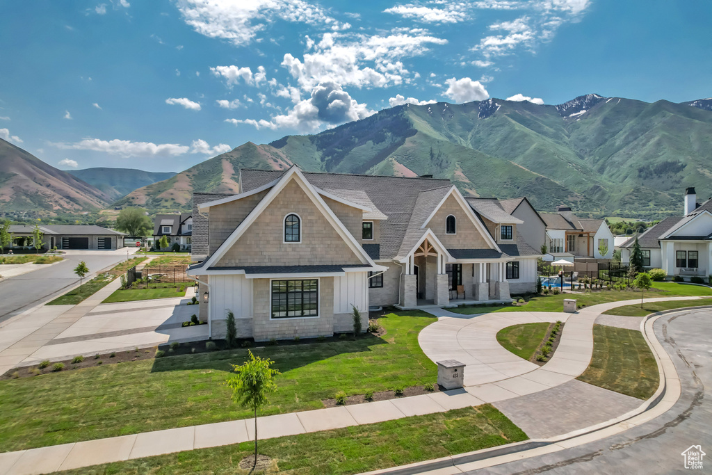 View of front of home with board and batten siding, a mountain view, a front lawn, a residential view, and a porch