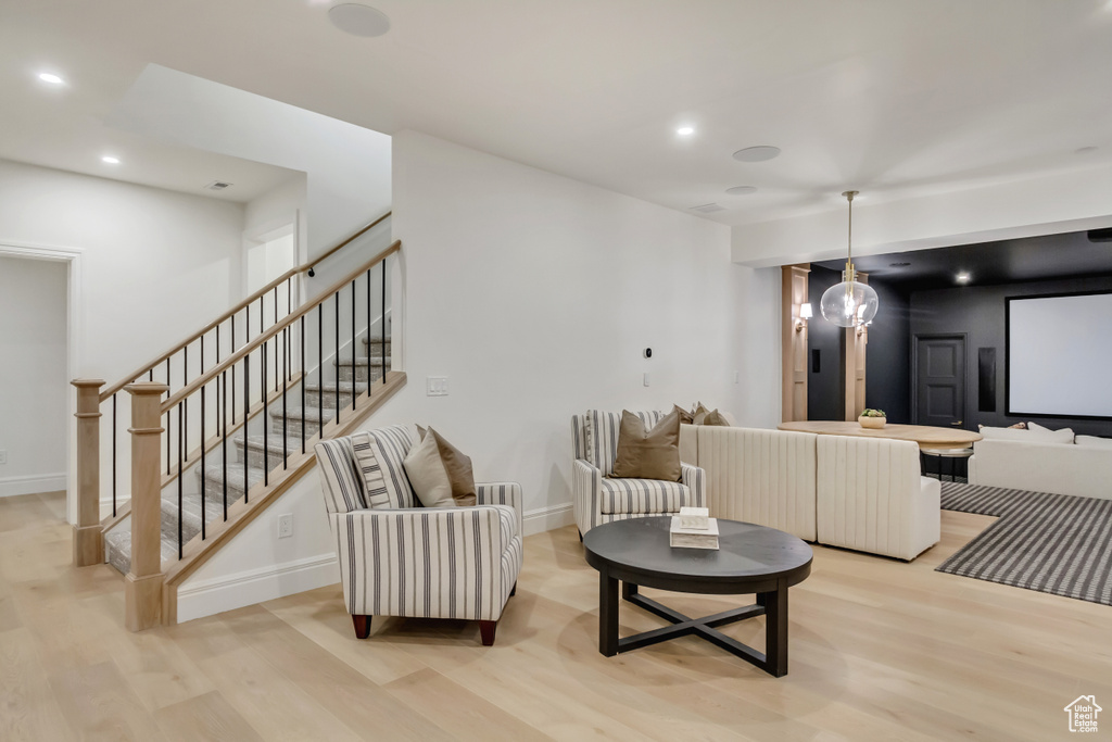 Living room with light wood-style floors, stairs, and recessed lighting
