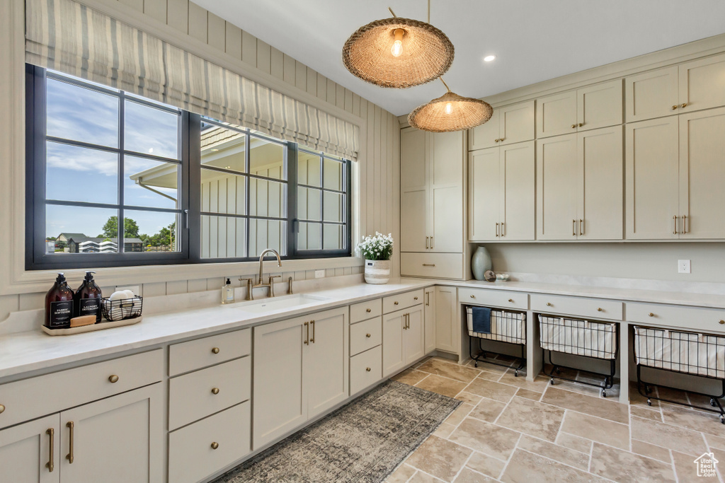 Kitchen with stone tile floors, decorative light fixtures, light countertops, and recessed lighting