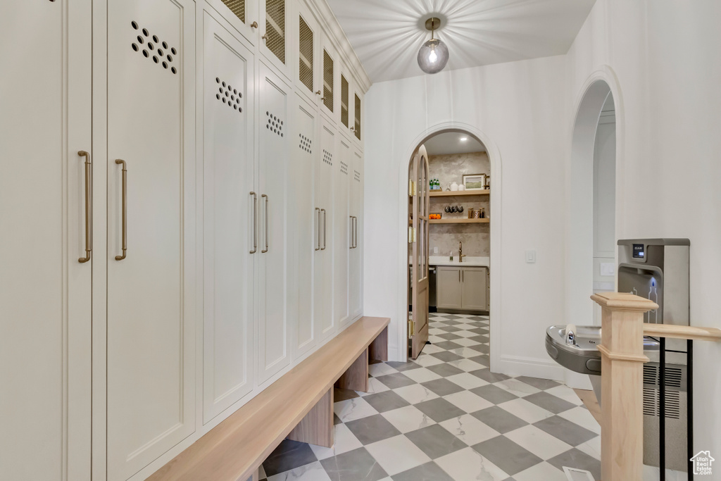 Mudroom with light flooring, arched walkways, and a sink