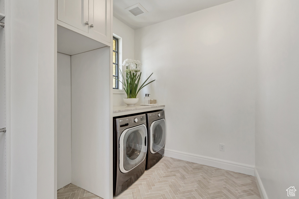 Laundry room with washer and clothes dryer and cabinet space