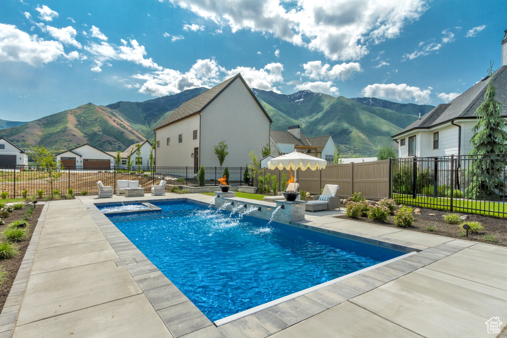 View of swimming pool featuring a mountain view, a patio, and a fenced backyard