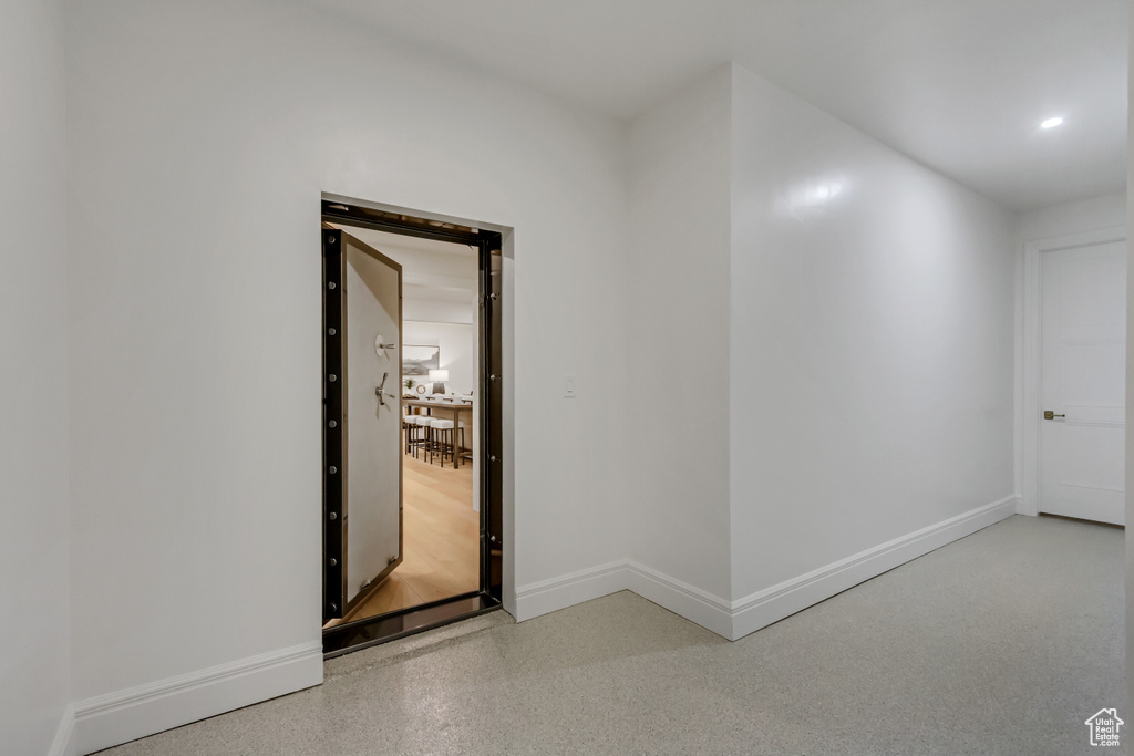 Corridor featuring dark speckled floor and recessed lighting