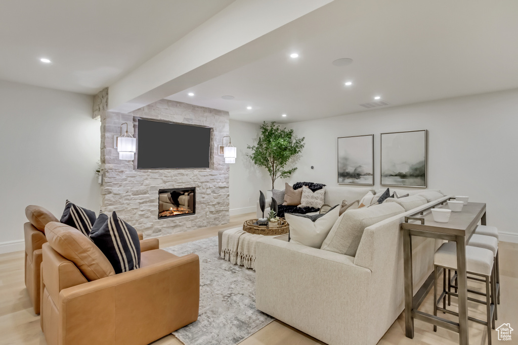 Living area with recessed lighting, a fireplace, and light wood finished floors