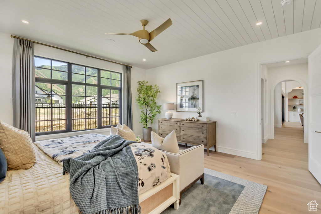 Bedroom with arched walkways, light wood finished floors, recessed lighting, wooden ceiling, and ceiling fan