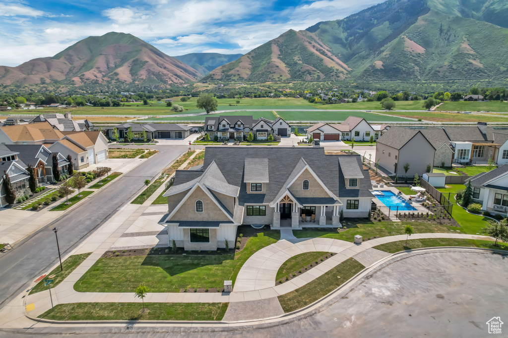 Aerial perspective of suburban area featuring a pool and a mountainous background