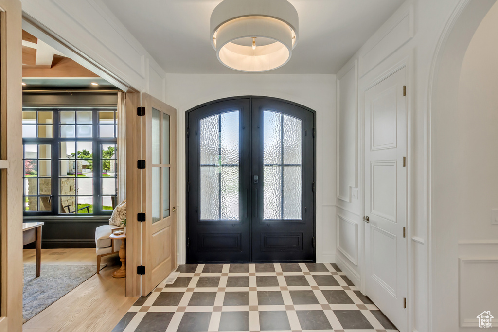Entrance foyer with arched walkways, french doors, and plenty of natural light