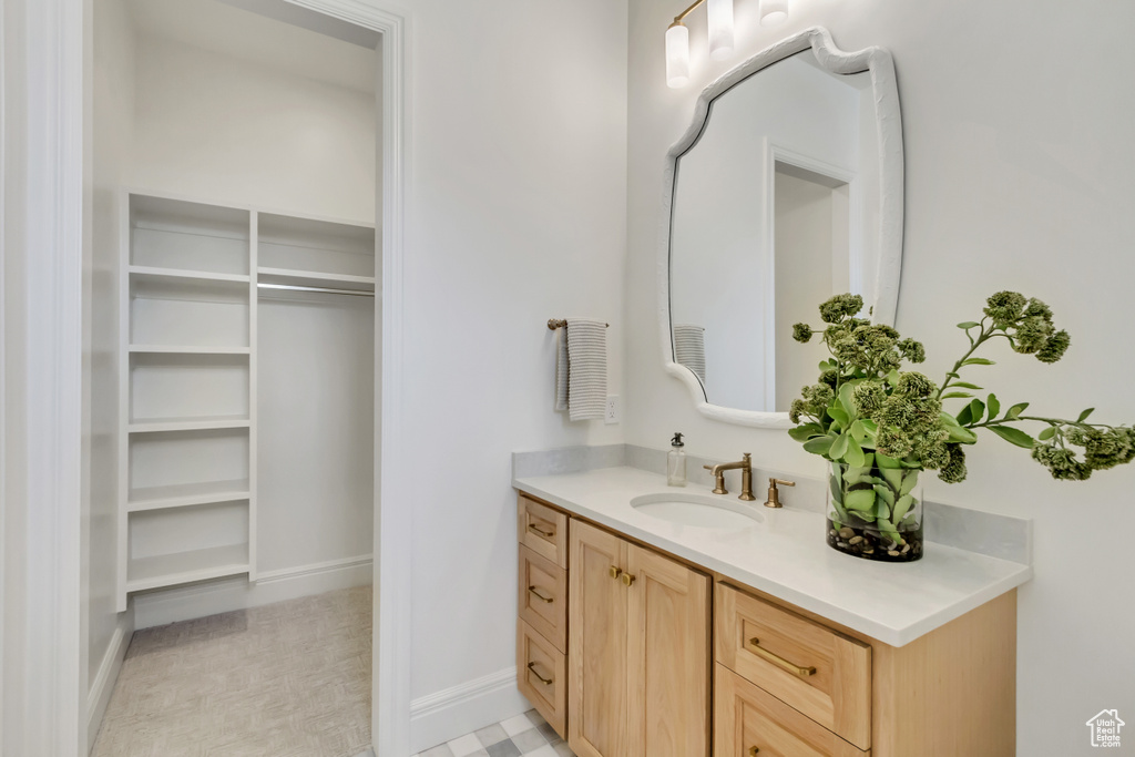 Bathroom featuring vanity and a walk in closet