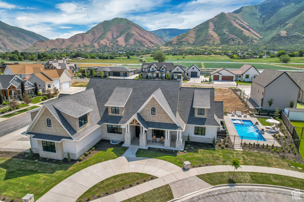 Aerial perspective of suburban area with a mountain backdrop and a pool area