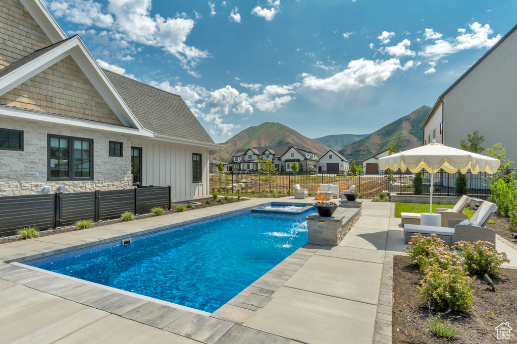 View of pool with a mountain view, a patio area, a fenced backyard, an in-ground hot tub, and an outdoor hangout area