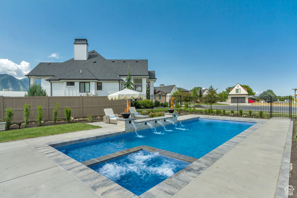 View of pool featuring a fenced backyard, a patio, and a pool with connected hot tub