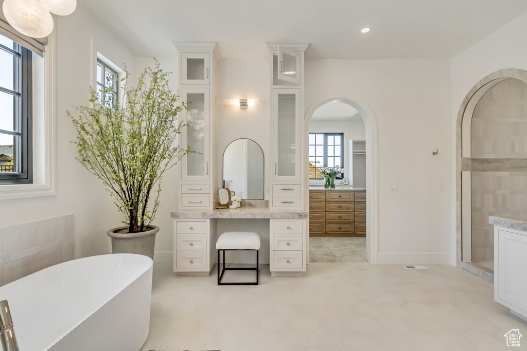 Full bath with vanity, a freestanding bath, and recessed lighting