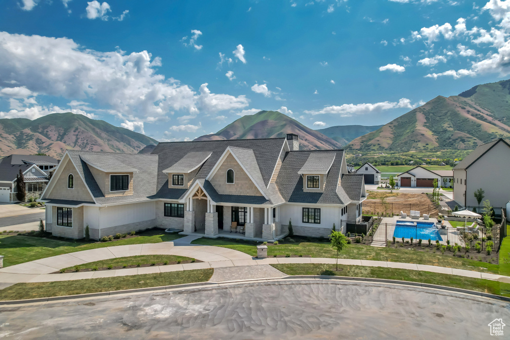 Shingle-style home featuring a mountain view and covered porch