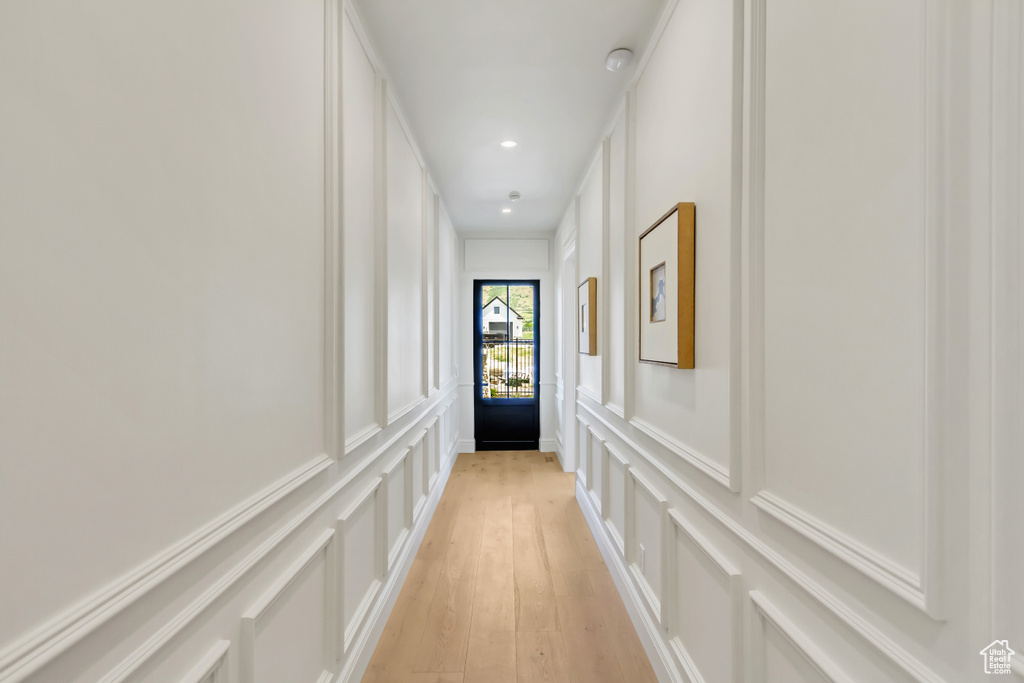 Hallway featuring a decorative wall, light wood-type flooring, and recessed lighting