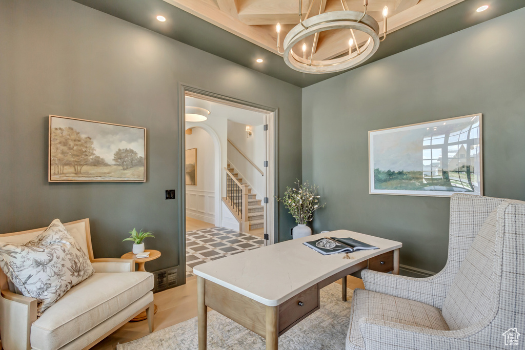Office space with a chandelier, arched walkways, recessed lighting, and a towering ceiling