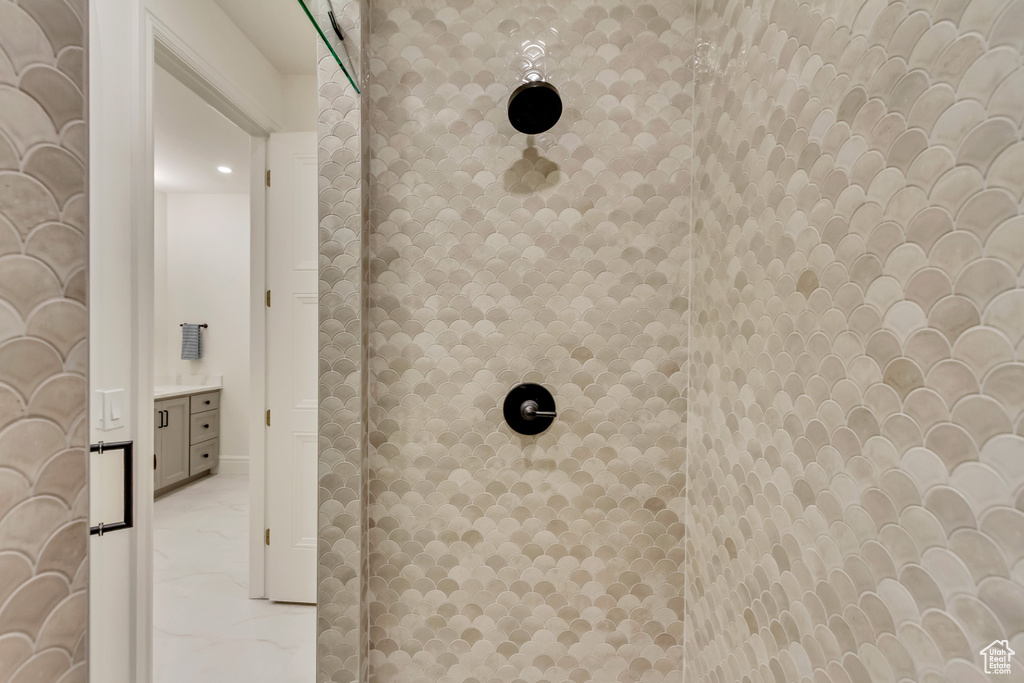 Bathroom view of tiled shower and vanity