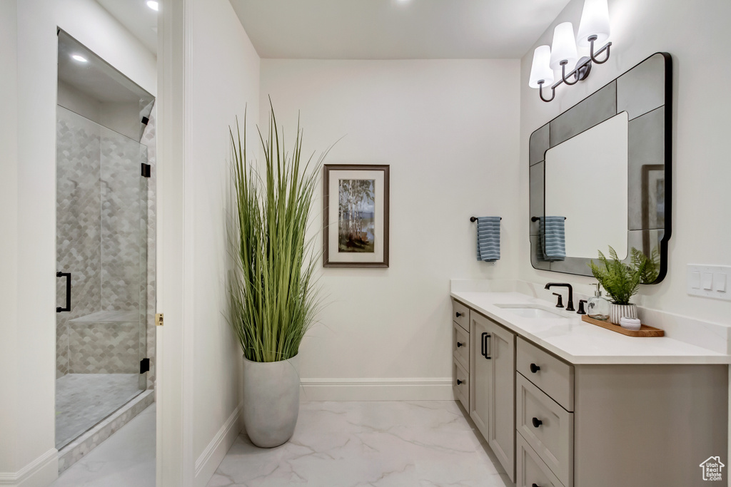 Full bathroom with vanity, marble look tiles, a stall shower, and recessed lighting