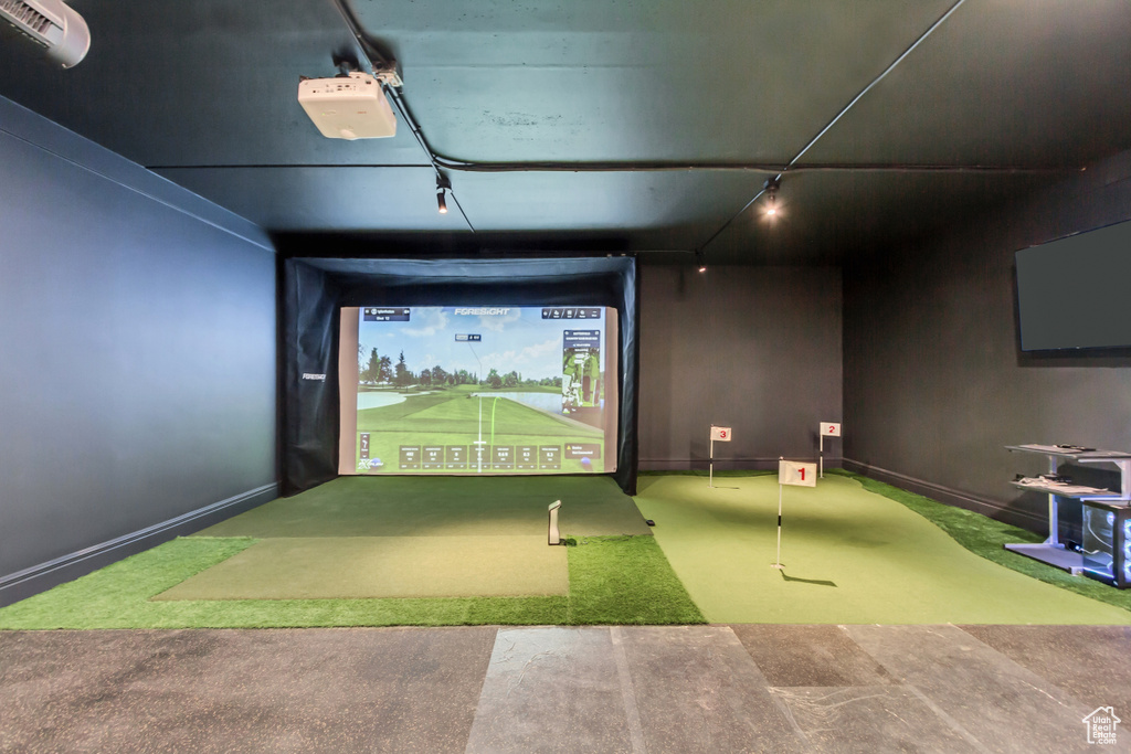Recreation room featuring golf simulator, rail lighting, and carpet