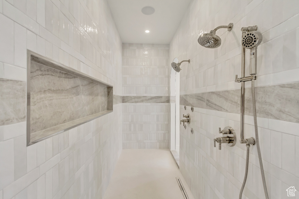 Bathroom with a tile shower and tile walls