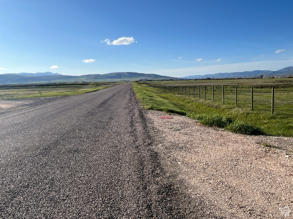 View of asphalt road featuring a mountain view and a rural view