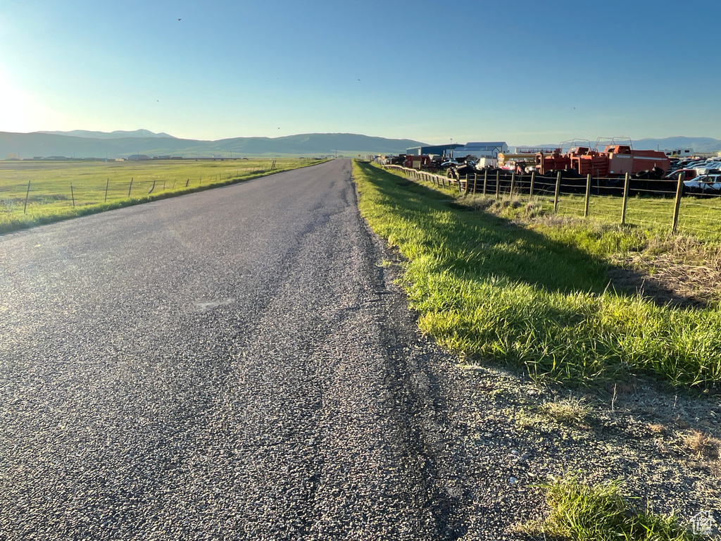 View of asphalt street with a view of countryside and a mountain view