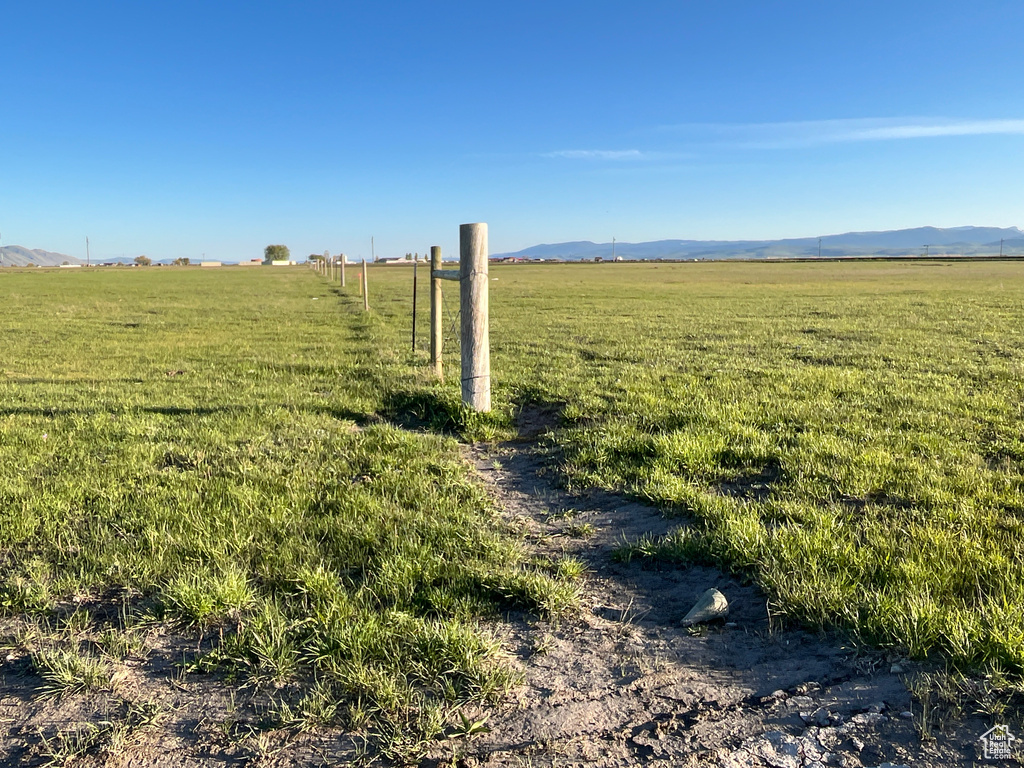 View of green lawn with a view of rural / pastoral area and a mountain view