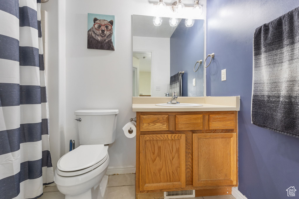 Bathroom featuring tile patterned floors, vanity, toilet, and baseboards