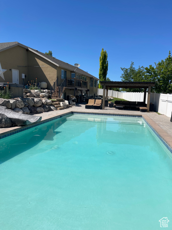 View of swimming pool featuring stairs, a fenced backyard, and a patio