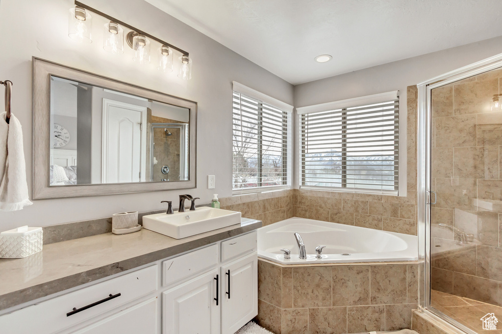 Full bath featuring vanity, a garden tub, and a stall shower