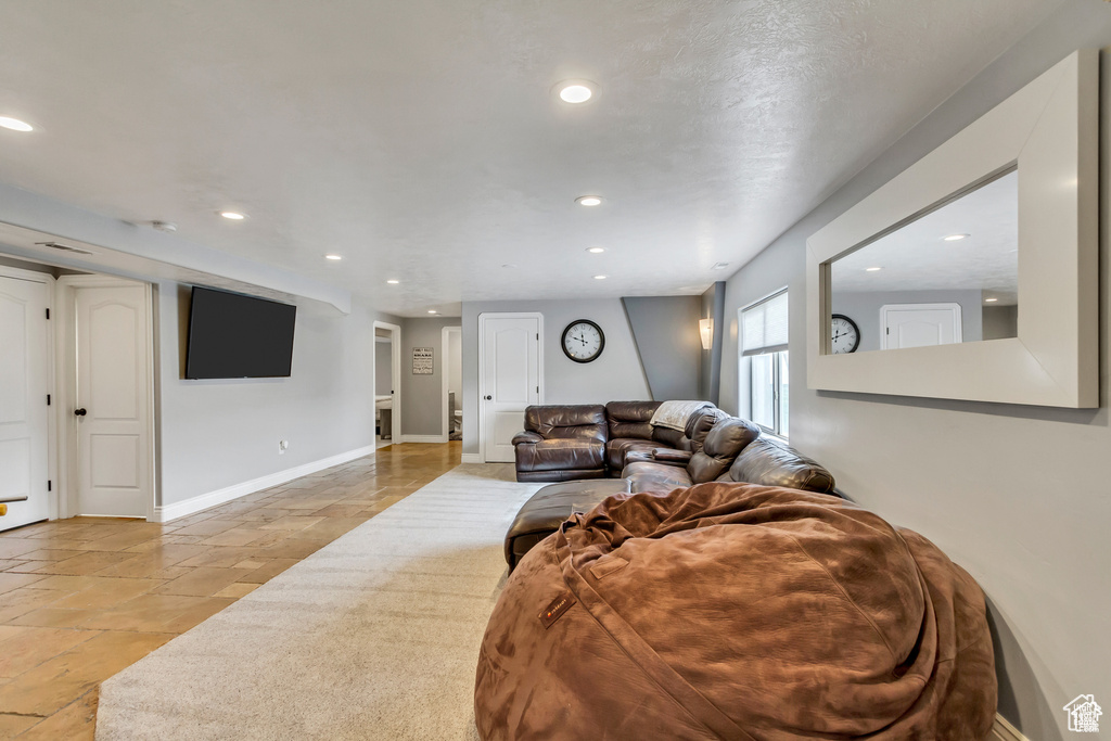 Living room with recessed lighting, stone tile flooring, and baseboards
