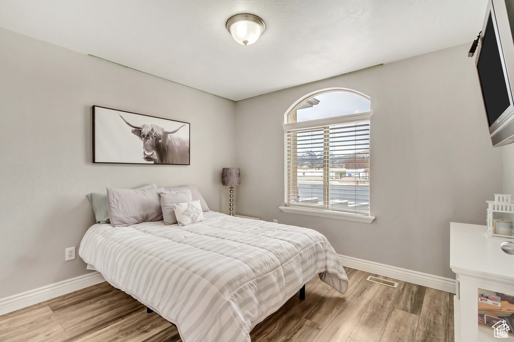 Bedroom featuring baseboards and wood finished floors
