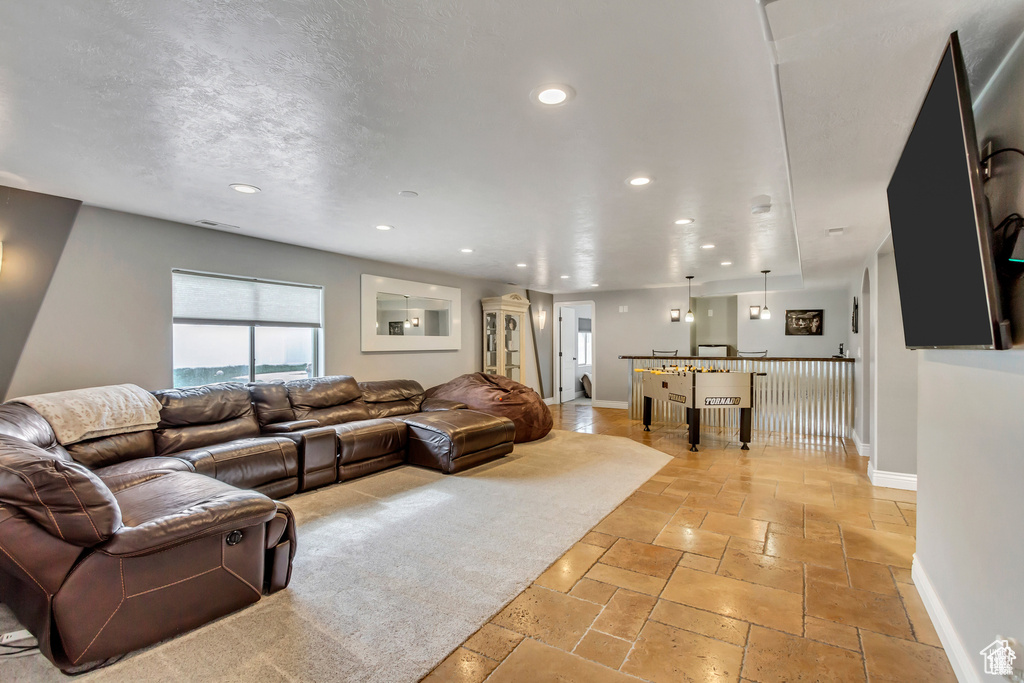 Living room featuring recessed lighting, stone tile floors, and baseboards