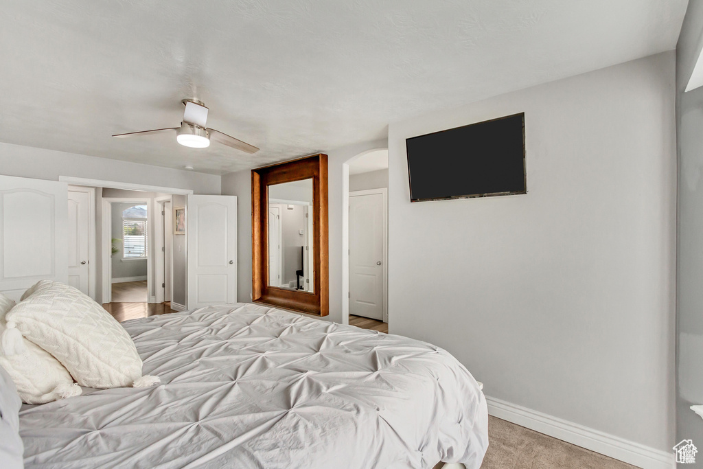 Bedroom with baseboards, arched walkways, and a ceiling fan