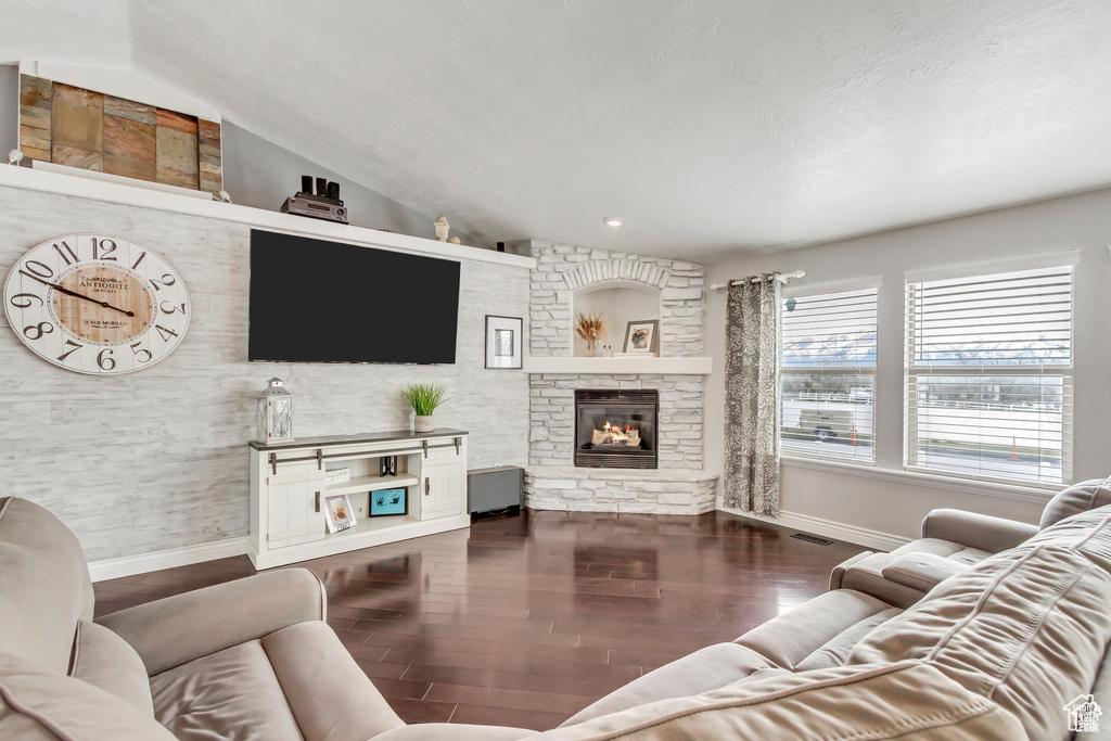 Living area with baseboards, a fireplace, and wood finished floors