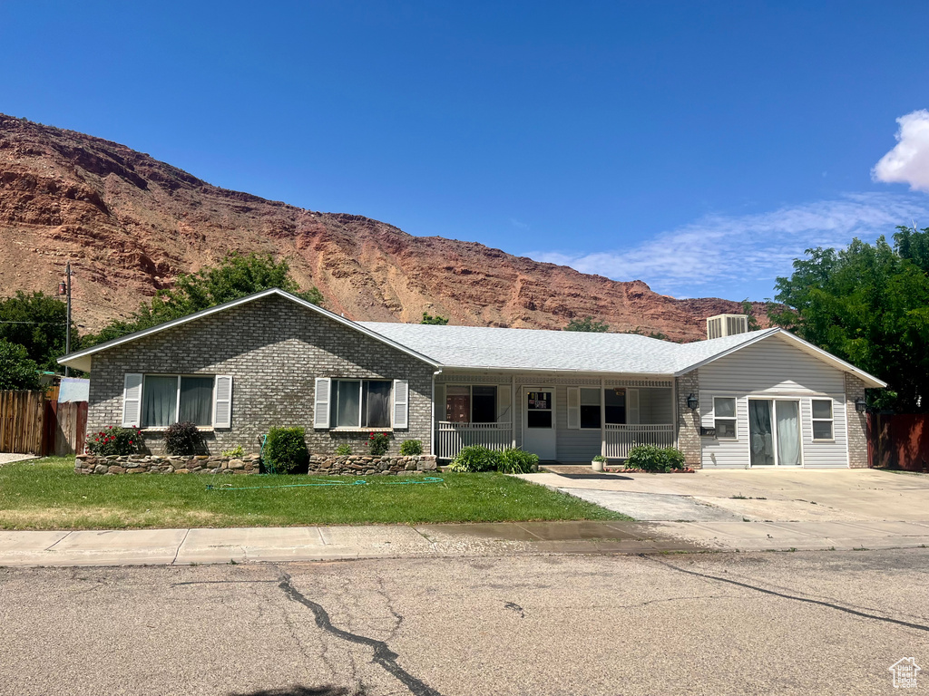 Ranch-style house featuring a mountain view, brick siding, and a porch