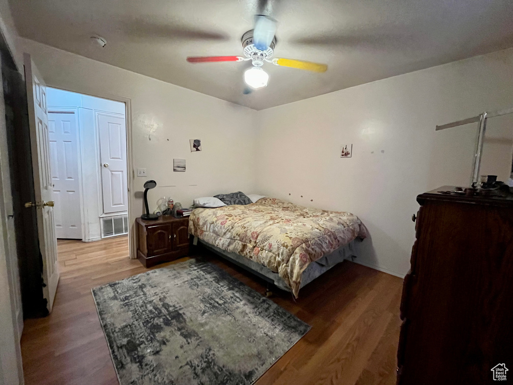 Bedroom with wood finished floors, a ceiling fan, and baseboards