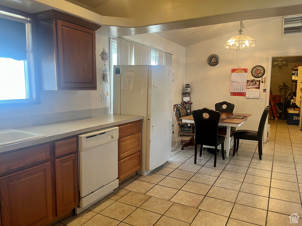 Kitchen featuring white appliances, light tile patterned floors, plenty of natural light, and light countertops