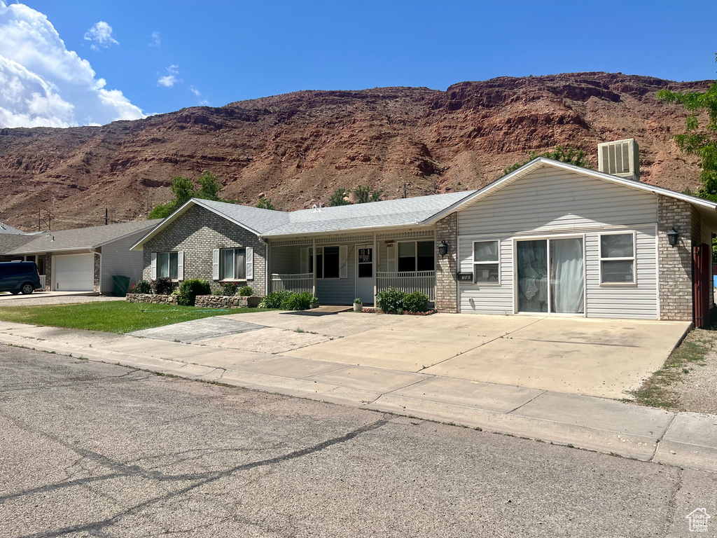 Ranch-style house featuring brick siding, a mountain view, and a porch