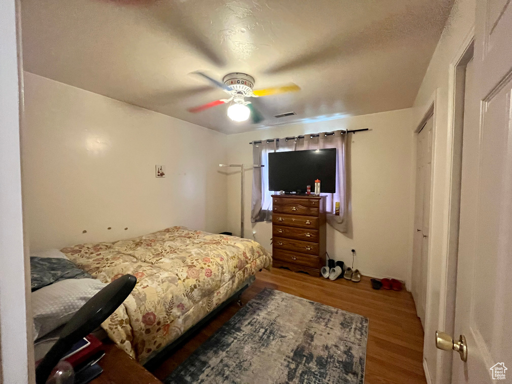 Bedroom with wood finished floors and a ceiling fan